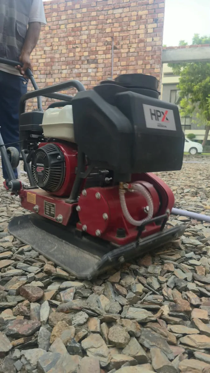 Plate compactor on stone soling at a 10 Marla house in Lake City Lahore