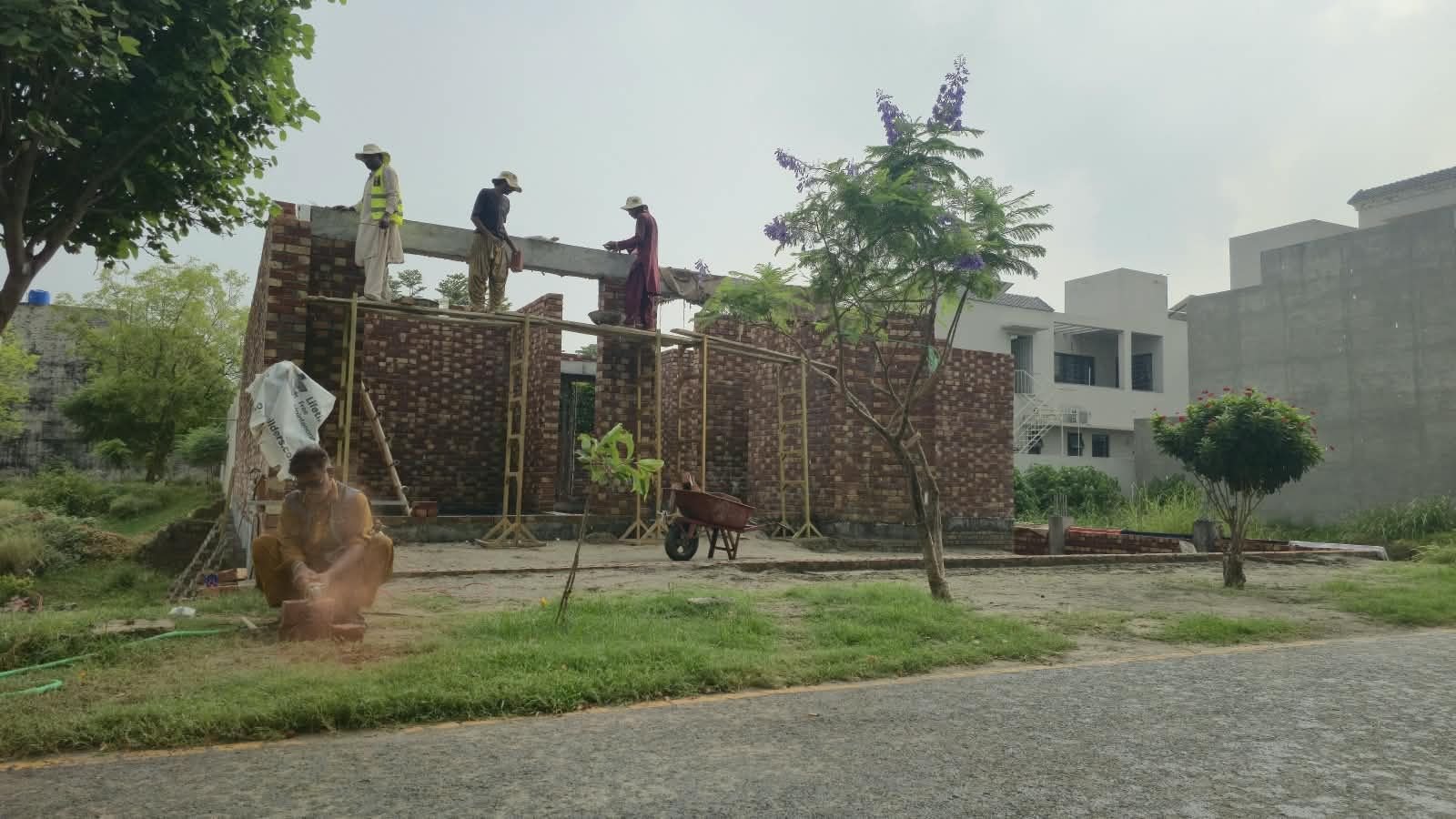 Lintel shuttering and scaffolding over brick walls during house construction in Lahore