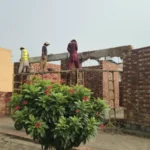 Masons and roof slab shuttering at lintel level on a house under construction in Lahore